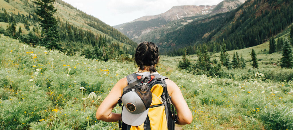 Personne de dos seule dans la nature, face à la montagne