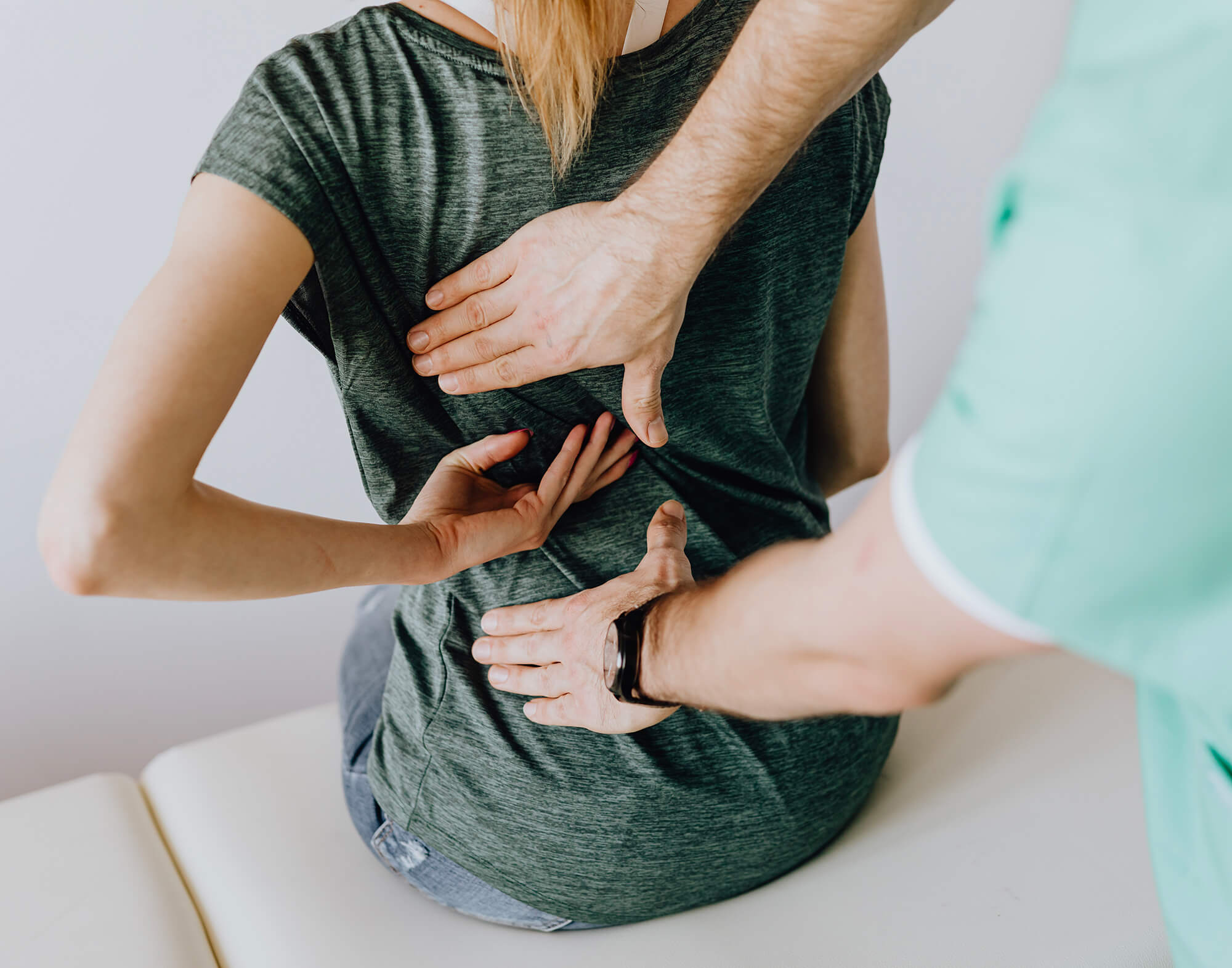 Ostéopathe qui pratique un massage sur le dos de sa patiente afin qu'elle se sente mieux