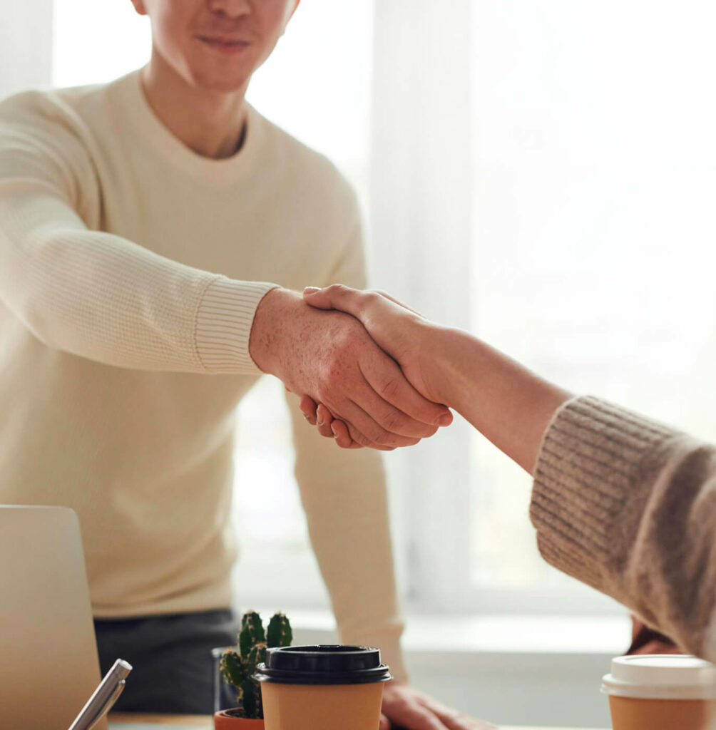 Une femme serre la main de son futur consultant : elle vient de choisir le meilleur bilan de compétences.